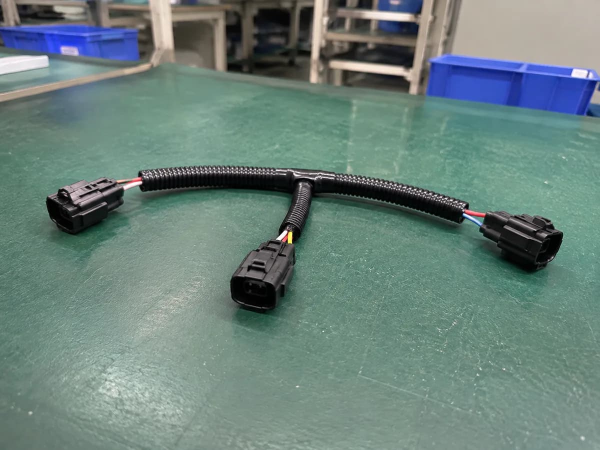 simple three-branch low-voltage automotive wire harness on a green factory workbench