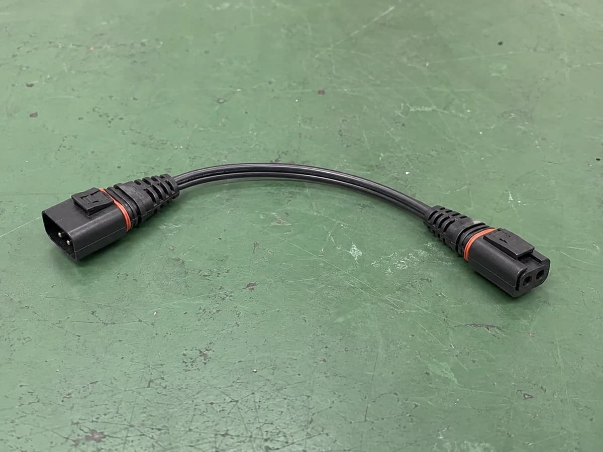 sealed two-position male and female cable assembly on a green factory workbench