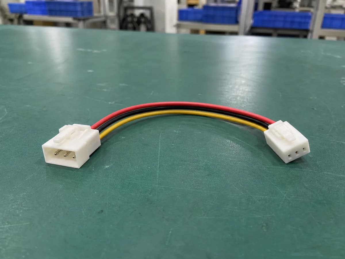 simple three-wire male and female inline connector assembly on a green factory workbench